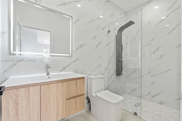 a bathroom with a sink a toilet and shower