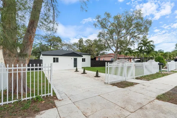 a view of a house with backyard and a tree