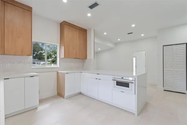 a kitchen with white cabinets and sink