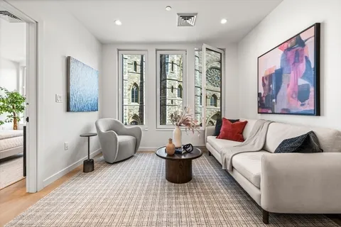 a living room with furniture potted plant and window