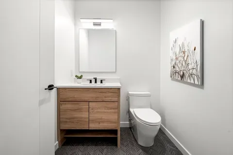 a bathroom with a toilet sink and mirror