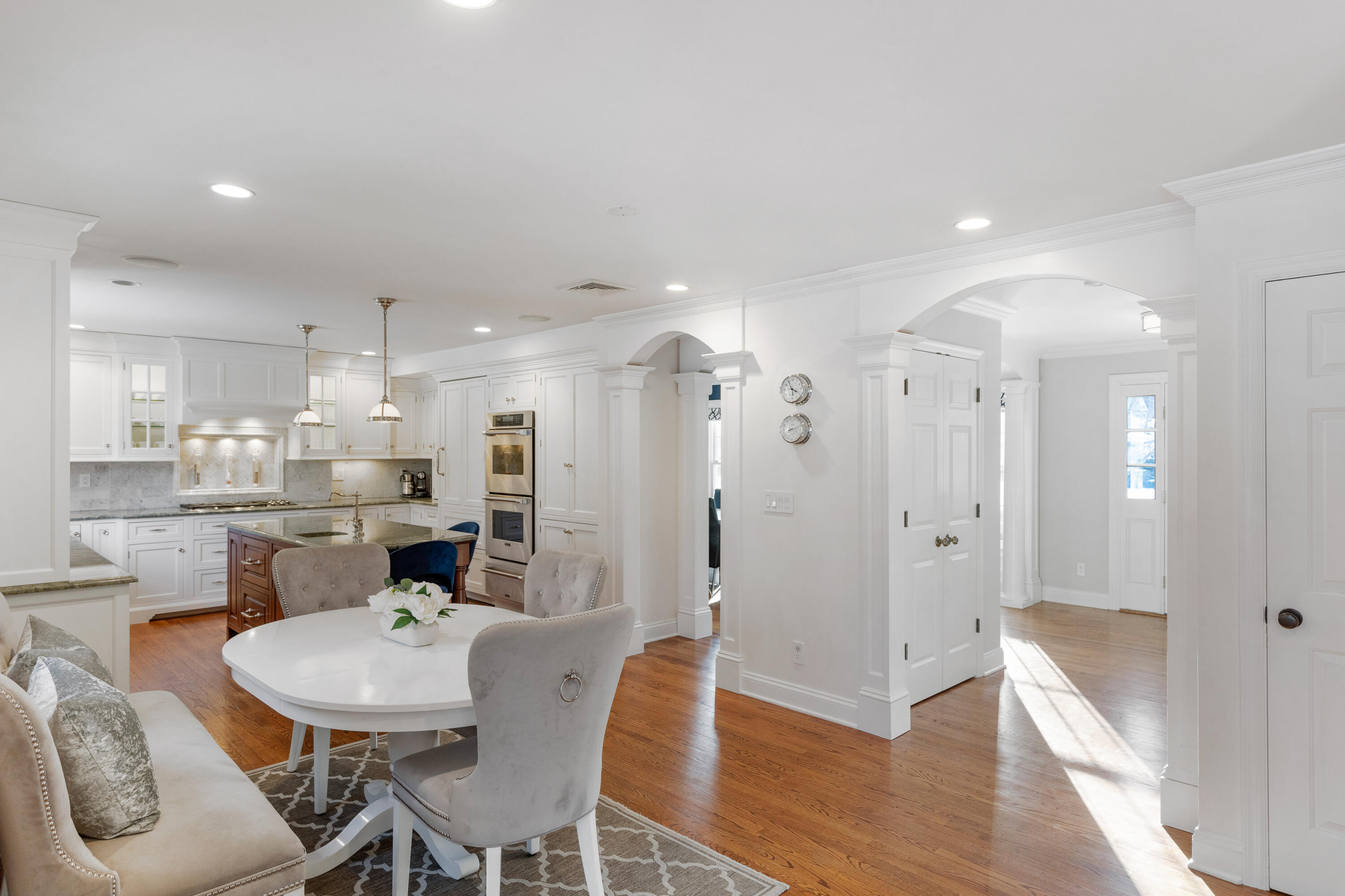 10 Chasmars Pond Road Darien, CT 06820 - Photo 12 of 32 a dining room with stainless steel appliances kitchen island granite countertop a table chairs and a refrigerator