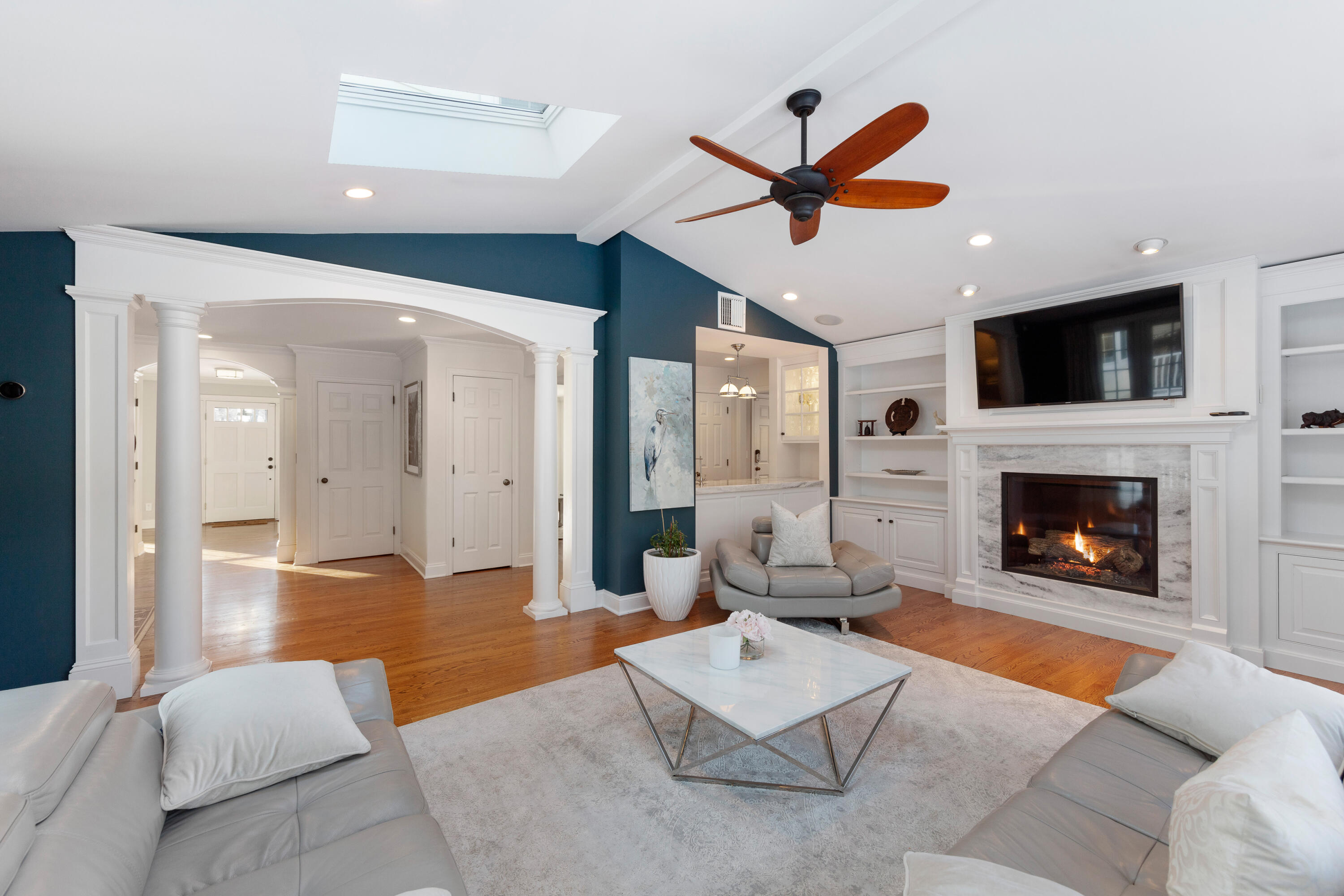 10 Chasmars Pond Road Darien, CT 06820 - Photo 6 of 32 a living room with furniture a fireplace and a ceiling fan
