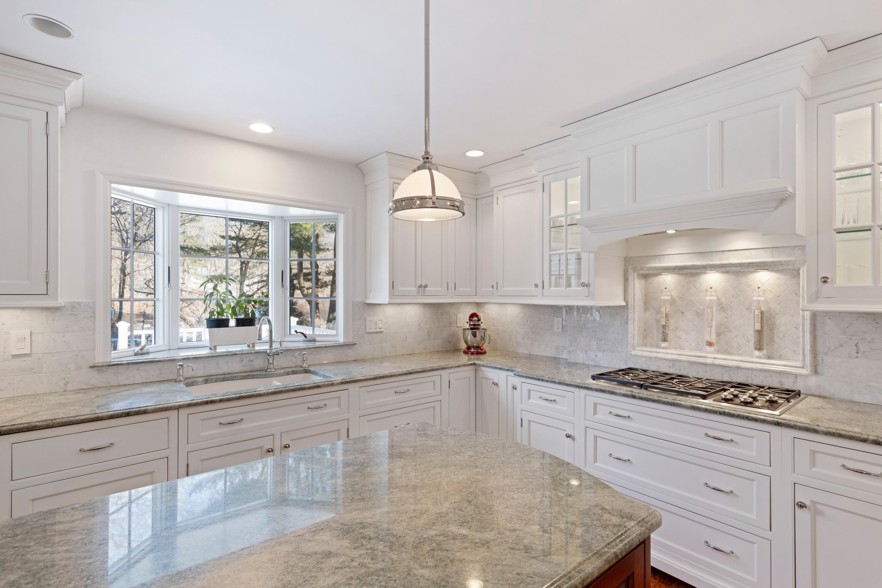 10 Chasmars Pond Road Darien, CT 06820 - Photo 10 of 32 a kitchen with granite countertop a stove a sink and white cabinets