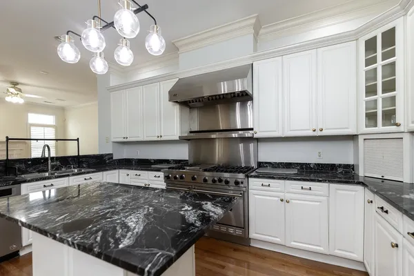 a kitchen with granite countertop a sink cabinets and stainless steel appliances