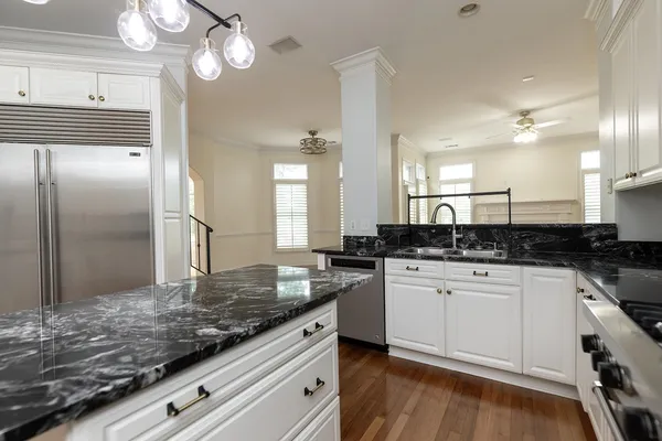 a kitchen with stainless steel appliances granite countertop a stove a sink and a refrigerator