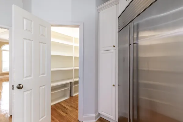 an empty room with wooden floor fireplace and windows