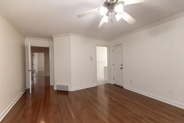 a view of a room with a chandelier potted plants and wooden floor