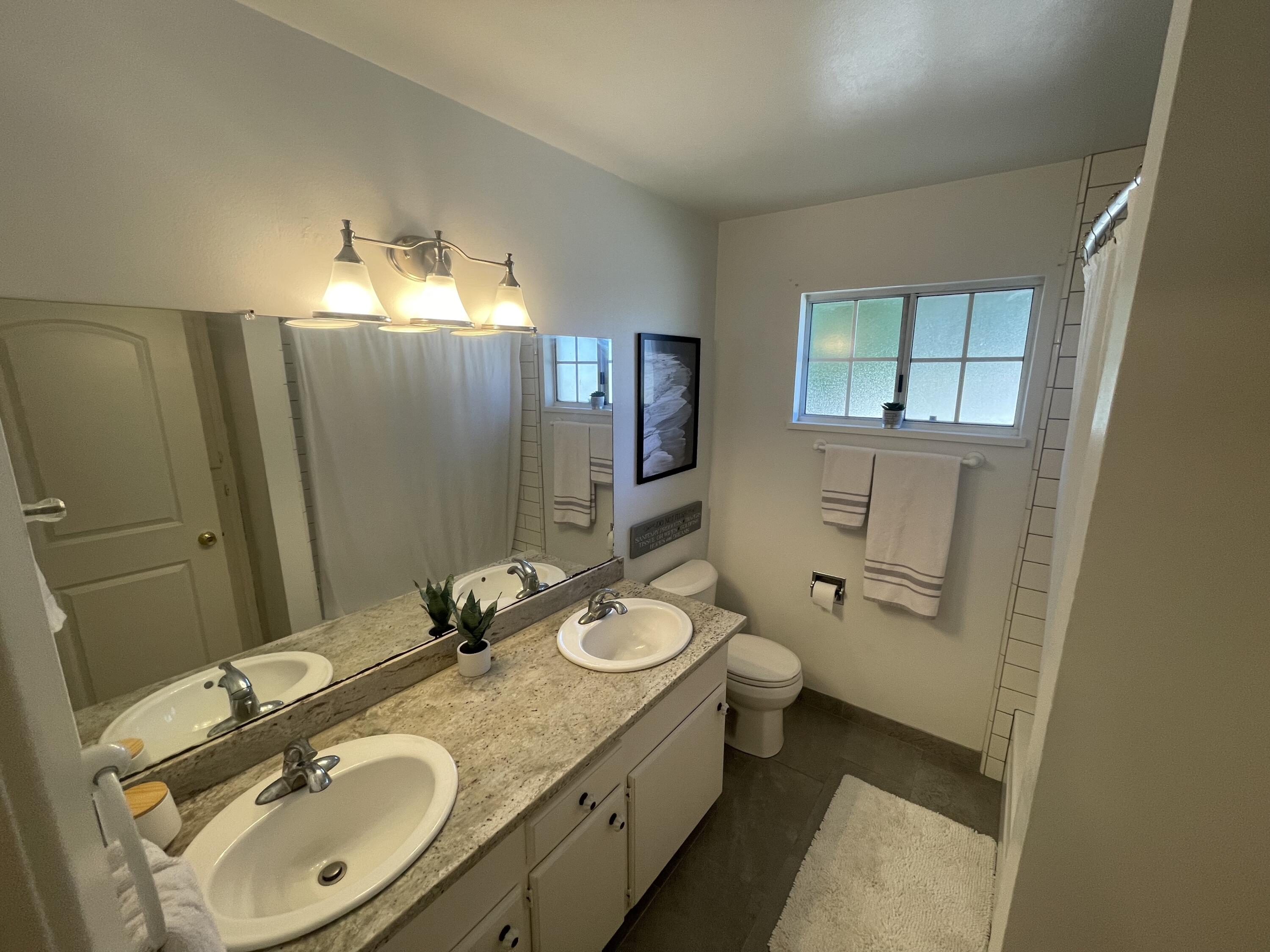 4170 Meander Drive Redding, CA 96001 - Photo 25 of 50 a bathroom with a double vanity sink toilet and mirror