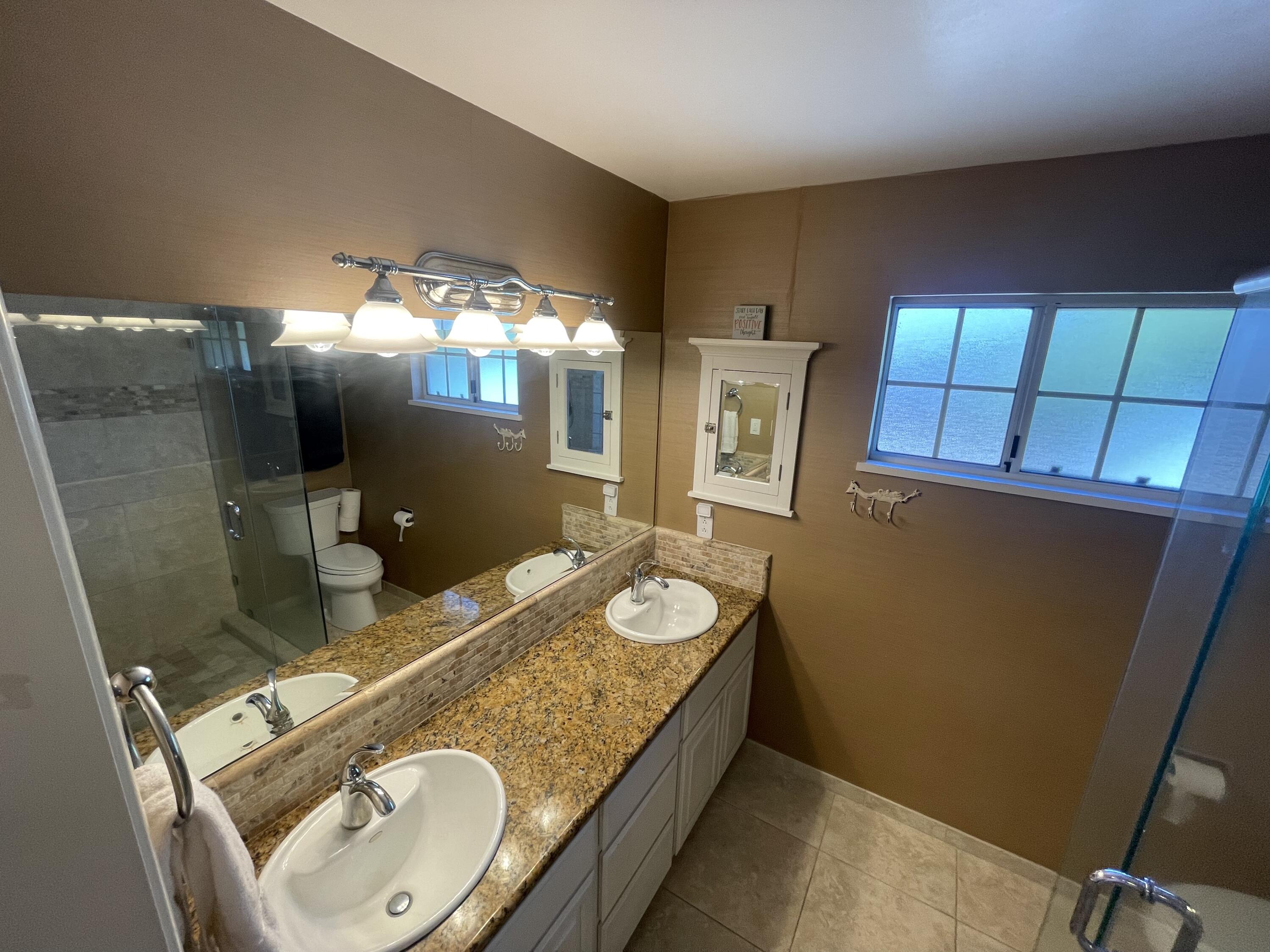 4170 Meander Drive Redding, CA 96001 - Photo 38 of 50 a bathroom with a granite countertop sink a mirror and a shower