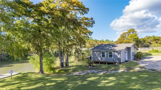 a room with stainless steel appliances lots of wooden furniture and large windows