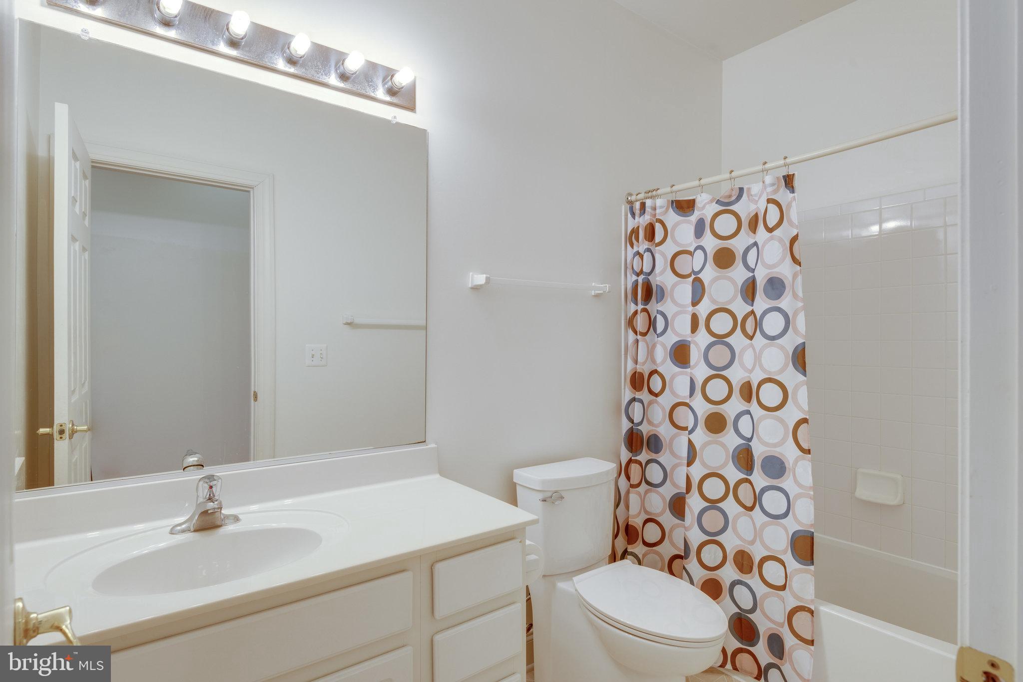 6884 Witton Circle Gainesville, VA 20155 - Photo 23 of 40 a bathroom with a sink a toilet and shower curtain