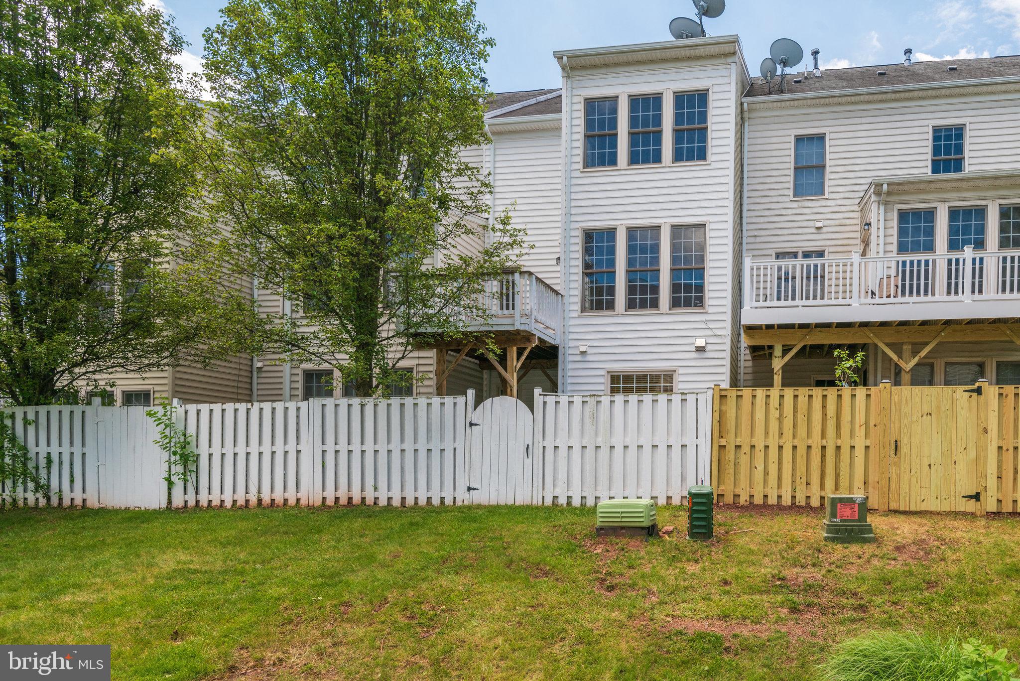 6884 Witton Circle Gainesville, VA 20155 - Photo 36 of 40 a white house that has a small yard and wooden fence