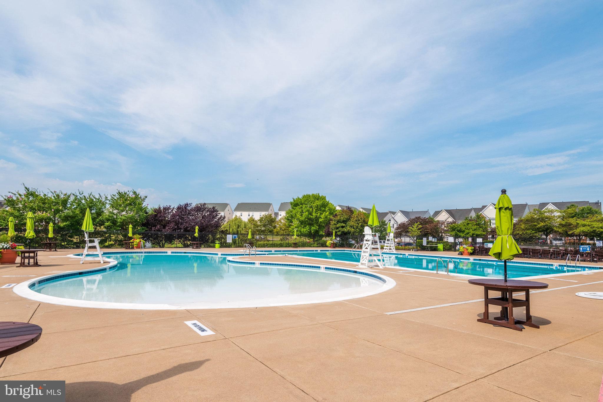 6884 Witton Circle Gainesville, VA 20155 - Photo 37 of 40 a view of a swimming pool with an outdoor seating and a lots of trees in the background