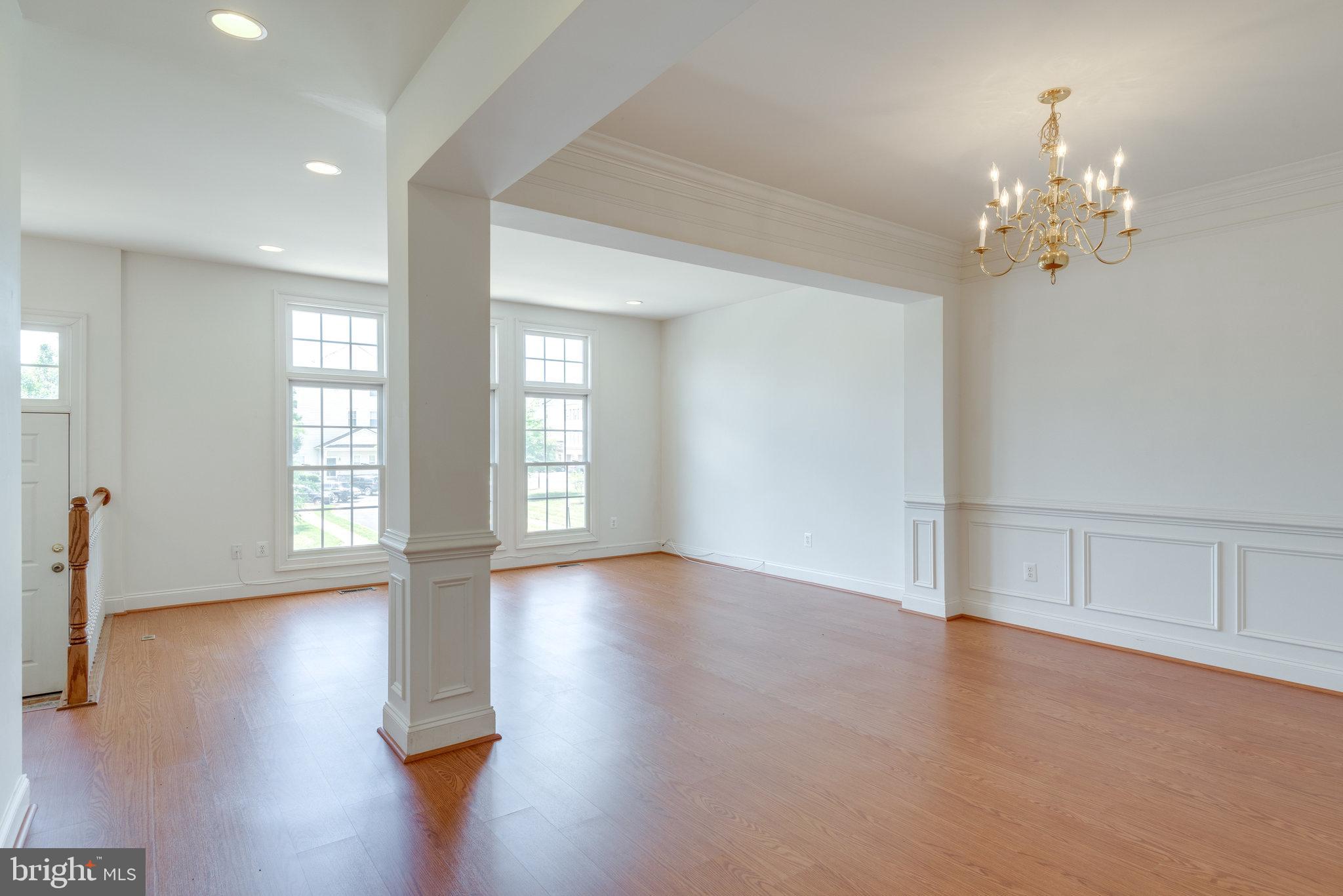 6884 Witton Circle Gainesville, VA 20155 - Photo 4 of 40 a view of an empty room with wooden floor and a window