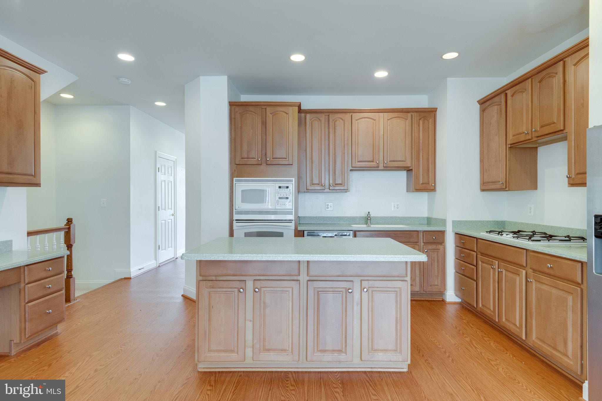 6884 Witton Circle Gainesville, VA 20155 - Photo 8 of 40 a kitchen that has a lot of cabinets in it and wooden floors