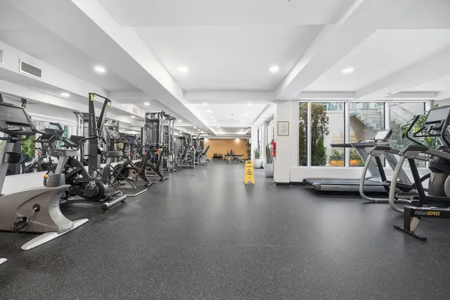 a view of a patio with couches table and chairs under an umbrella