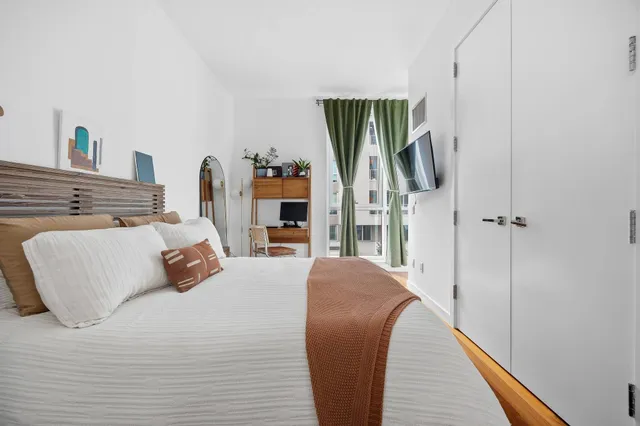 a bedroom with a bed a mirror and a flat screen tv