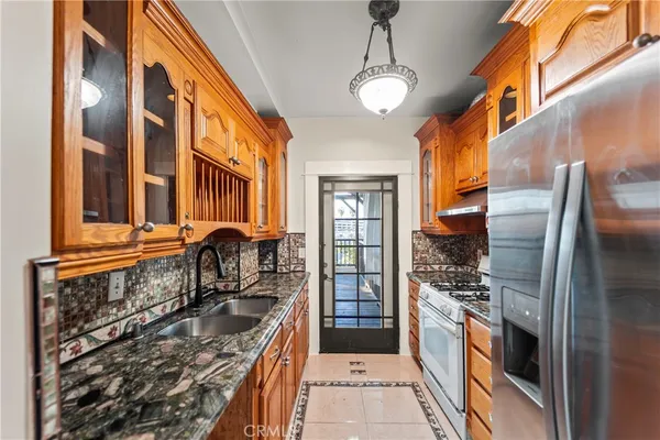 a kitchen with stainless steel appliances granite countertop a stove a sink and a refrigerator