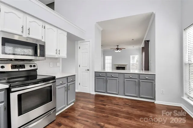 a kitchen with stainless steel appliances white cabinets and stove top oven