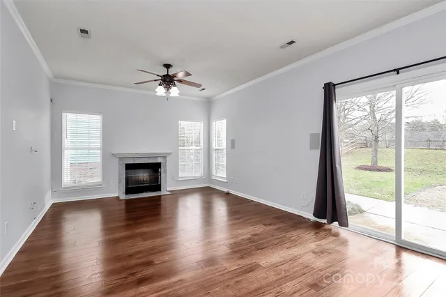 wooden floor fireplace and windows in an empty room