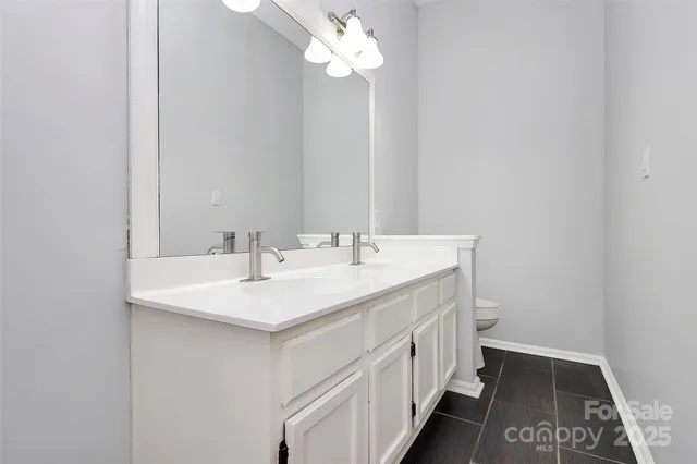 a bathroom with a sink a light fixture and a mirror