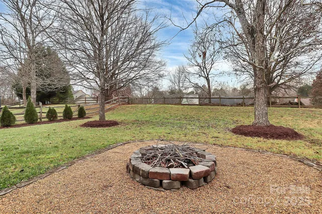 a front view of a house with a yard and a large tree