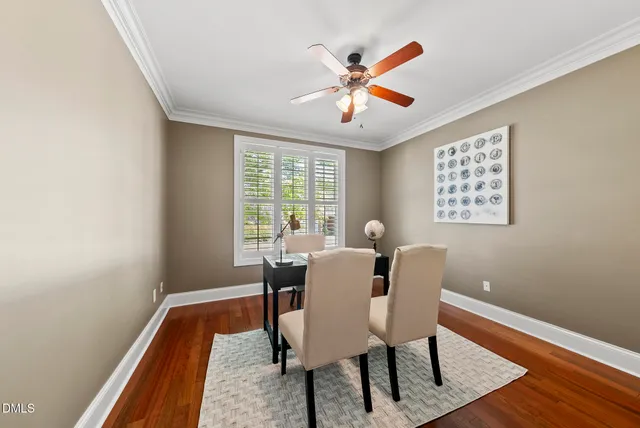 a dining room with wooden floor a chandelier a wooden table and chairs