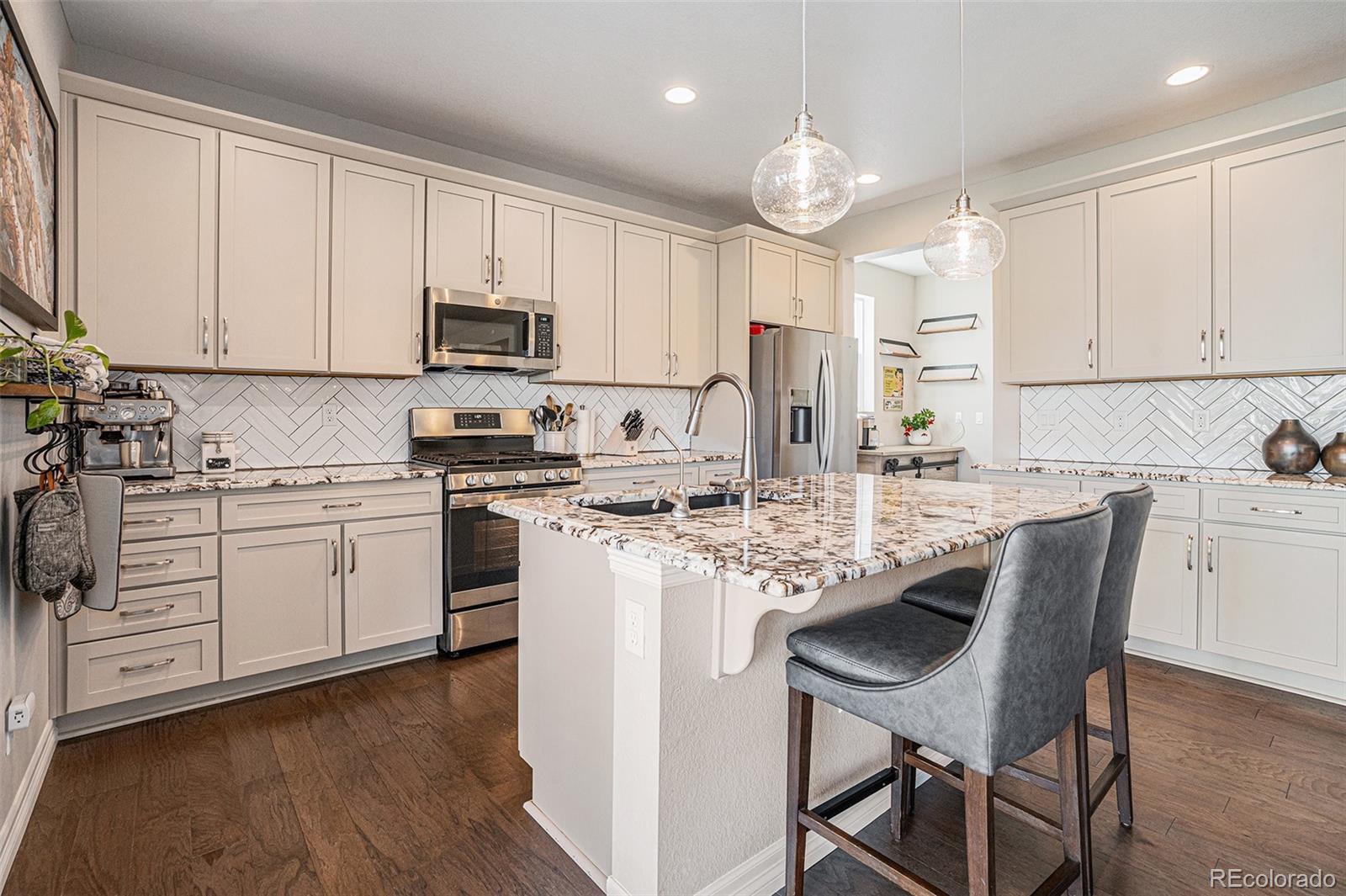 a kitchen with white cabinets stainless steel appliances and sink