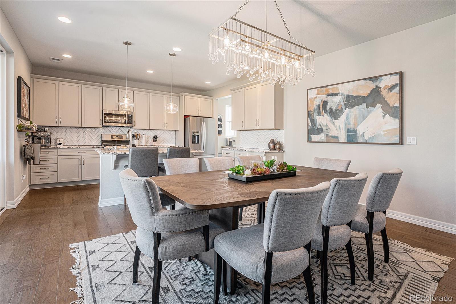 22011 East Stanford Circle Aurora, CO 80015 - Photo 11 of 43 a view of a dining room with furniture a kitchen and chandelier