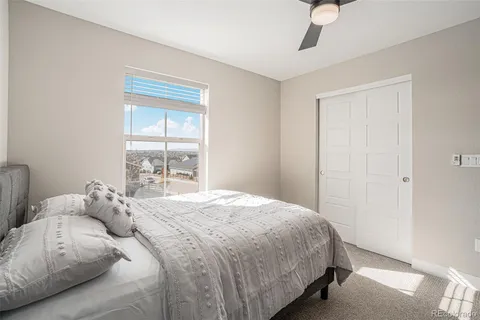 a bedroom with a bed and a large window