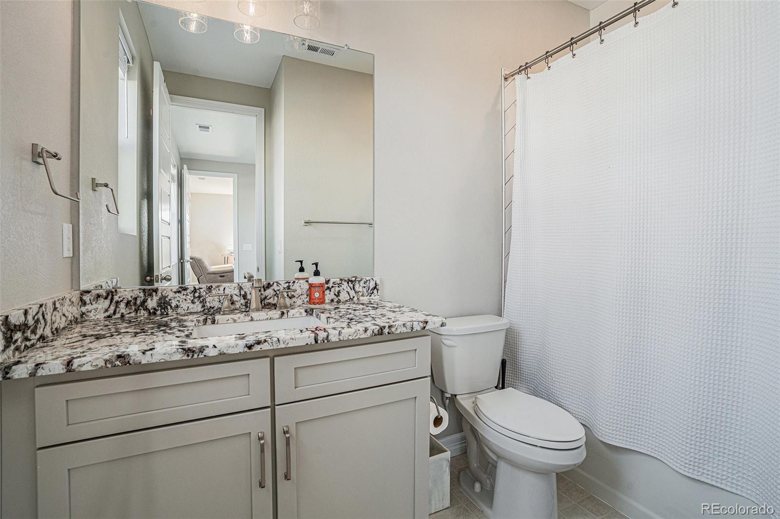 22011 East Stanford Circle Aurora, CO 80015 - Photo 34 of 43 a bathroom with a sink toilet and mirror