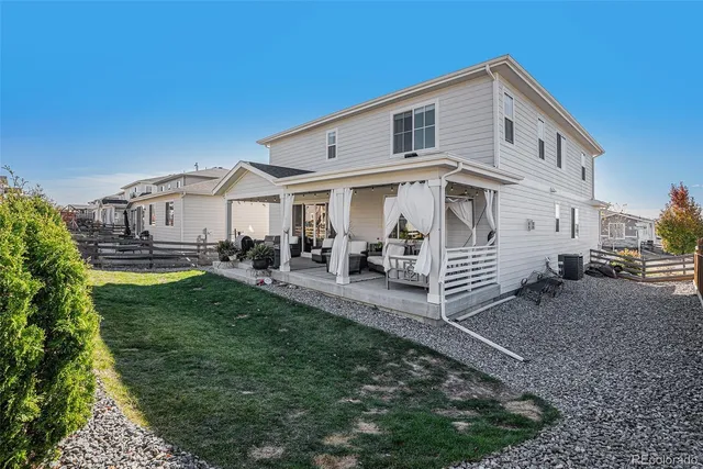 a view of a patio with table and chairs potted plants and floor to ceiling window