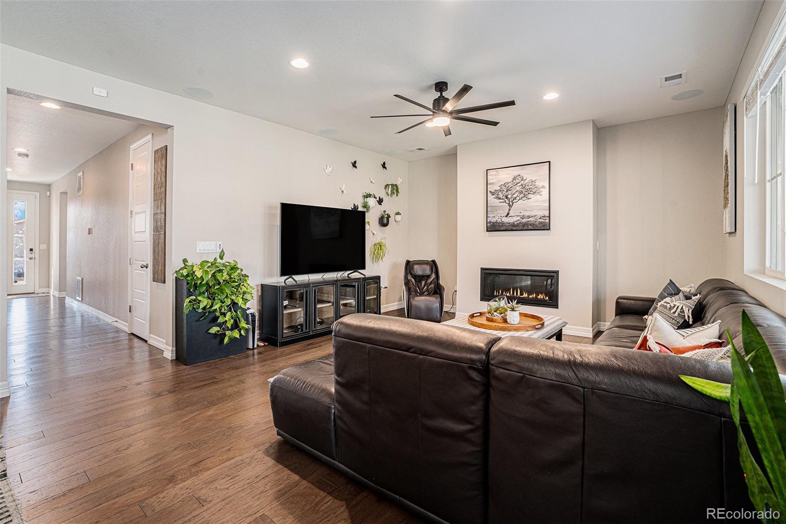 22011 East Stanford Circle Aurora, CO 80015 - Photo 5 of 43 a living room with furniture a flat screen tv and a fireplace
