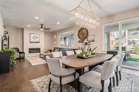 a view of a dining room and livingroom furniture wooden floor a chandelier