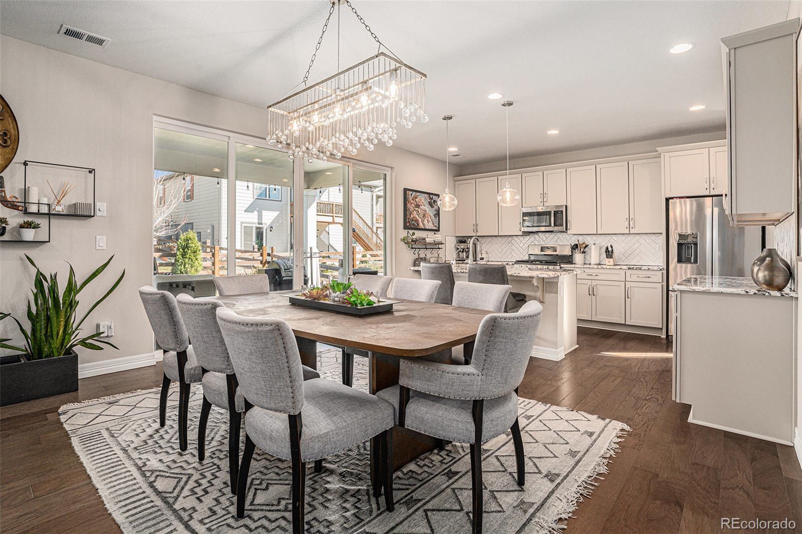 22011 East Stanford Circle Aurora, CO 80015 - Photo 10 of 43 a dining room with stainless steel appliances a dining table and chairs