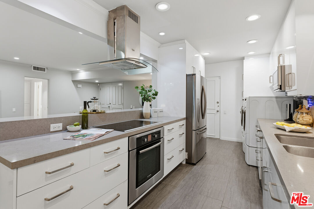1015 North Kings Road, Unit 110 West Hollywood, CA 90069 - Photo 13 of 36 a kitchen with stainless steel appliances a sink stove and refrigerator