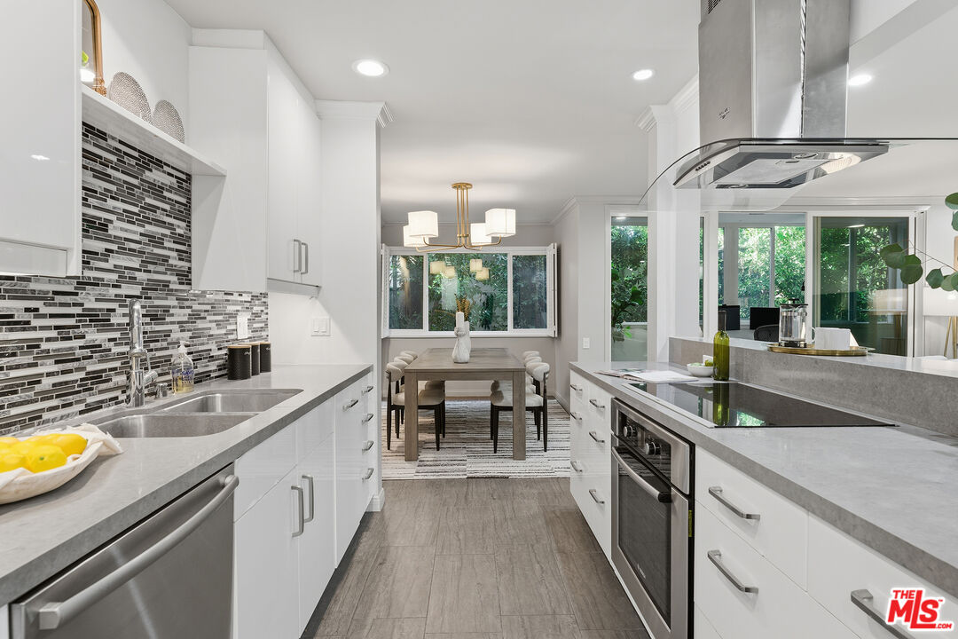 1015 North Kings Road, Unit 110 West Hollywood, CA 90069 - Photo 15 of 36 a kitchen with stainless steel appliances granite countertop a sink and a stove