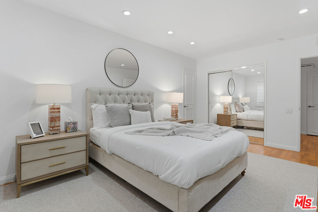 1015 North Kings Road, Unit 110 West Hollywood, CA 90069 - Photo 24 of 36 a bedroom with bed and a mirror