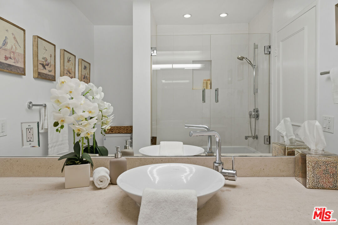 1015 North Kings Road, Unit 110 West Hollywood, CA 90069 - Photo 27 of 36 a bathroom with a tub sink and mirror