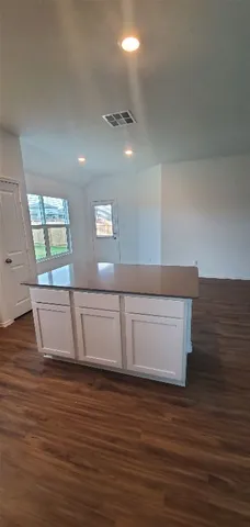 a view of an empty room with wooden floor and staircase