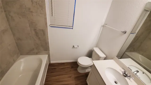 a white toilet sitting next to a bath tub
