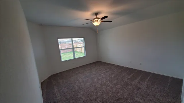 a view of a big room with windows and chandelier fan