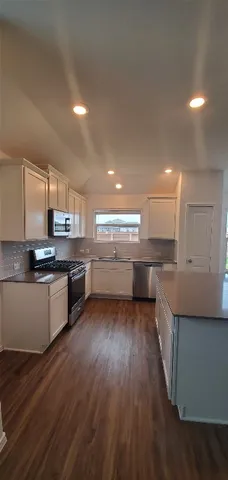 a kitchen with stainless steel appliances kitchen island wooden cabinets and granite counter tops