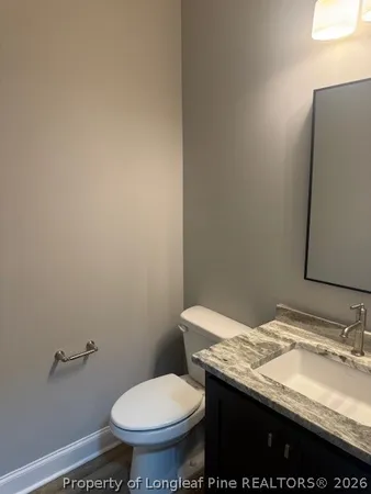a bathroom with a granite countertop toilet and a sink