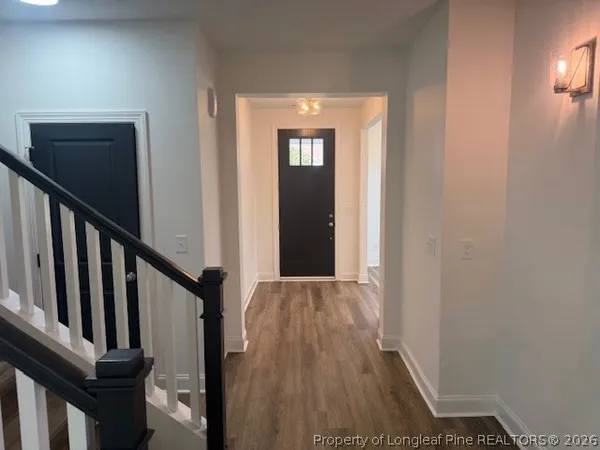 a view of a hallway with wooden floor and staircase