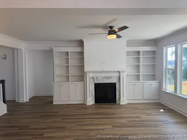 a view of an empty room with a fireplace and a window