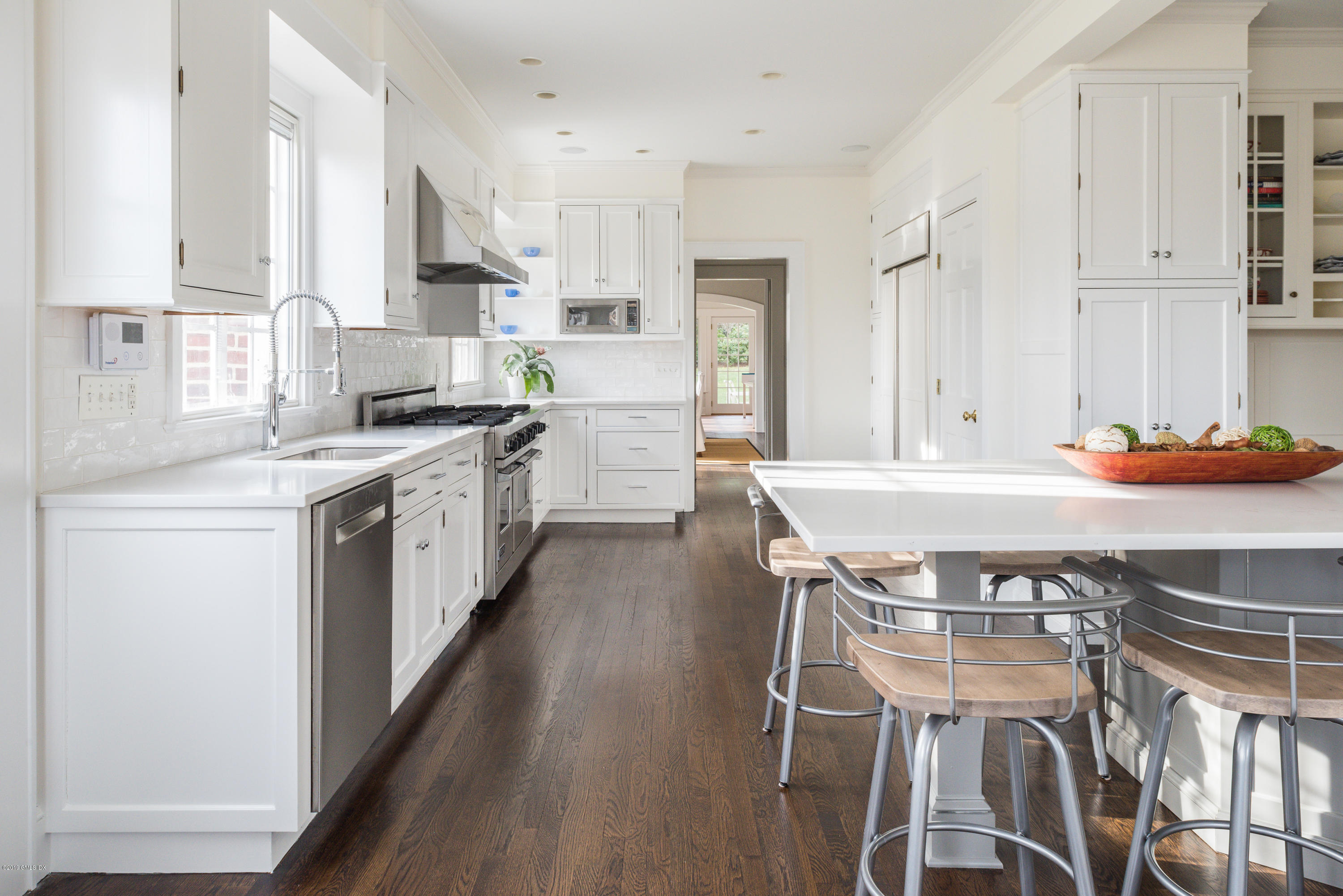 50 Upland Drive Greenwich, CT 06831 - Photo 17 of 34 a kitchen with stainless steel appliances a table chairs sink and cabinets