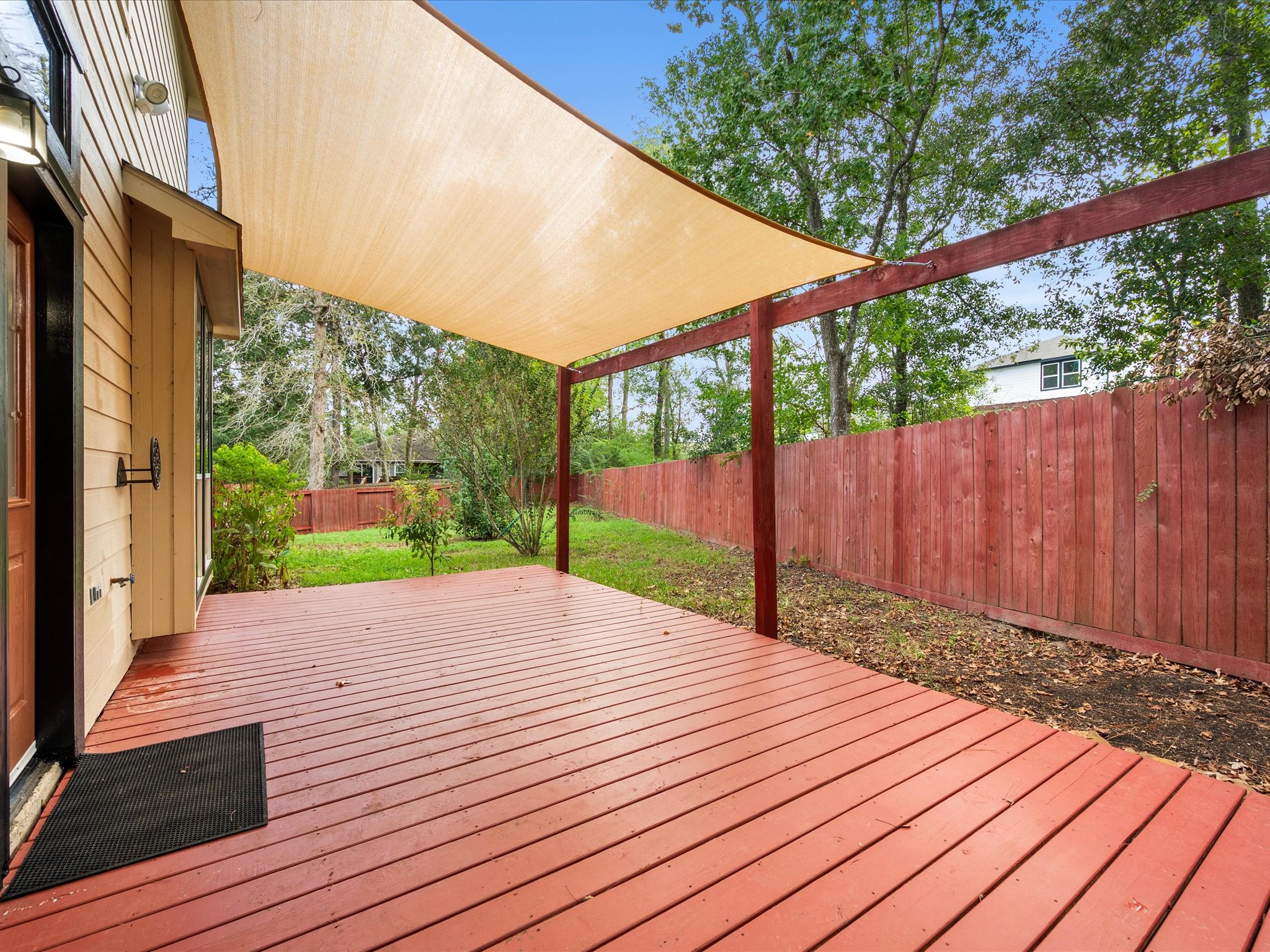 291 Sunset Path South Conroe, TX 77316 - Photo 31 of 39 An expansive shaded deck creates an inviting outdoor extension of the home, with plenty of room to gather and relax.