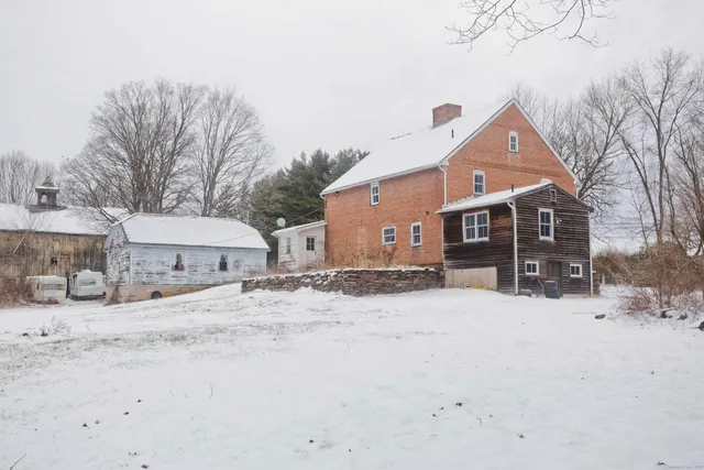 a front view of a house with a yard covered in snow